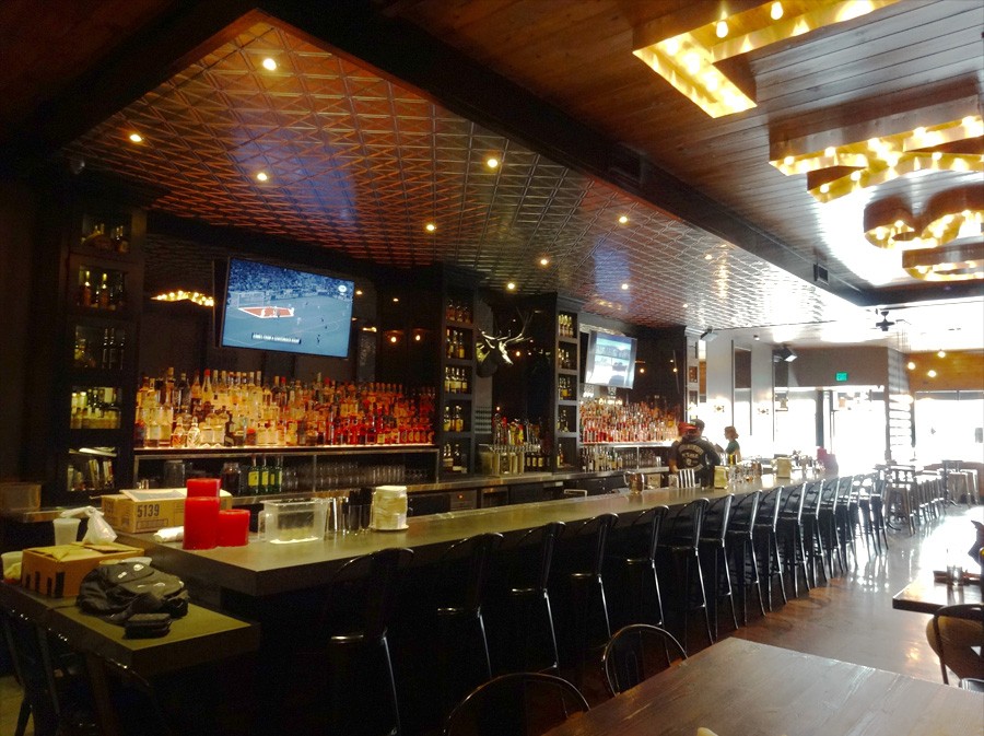 image of bar showing bar stools lined up and liquor displayed on back wall